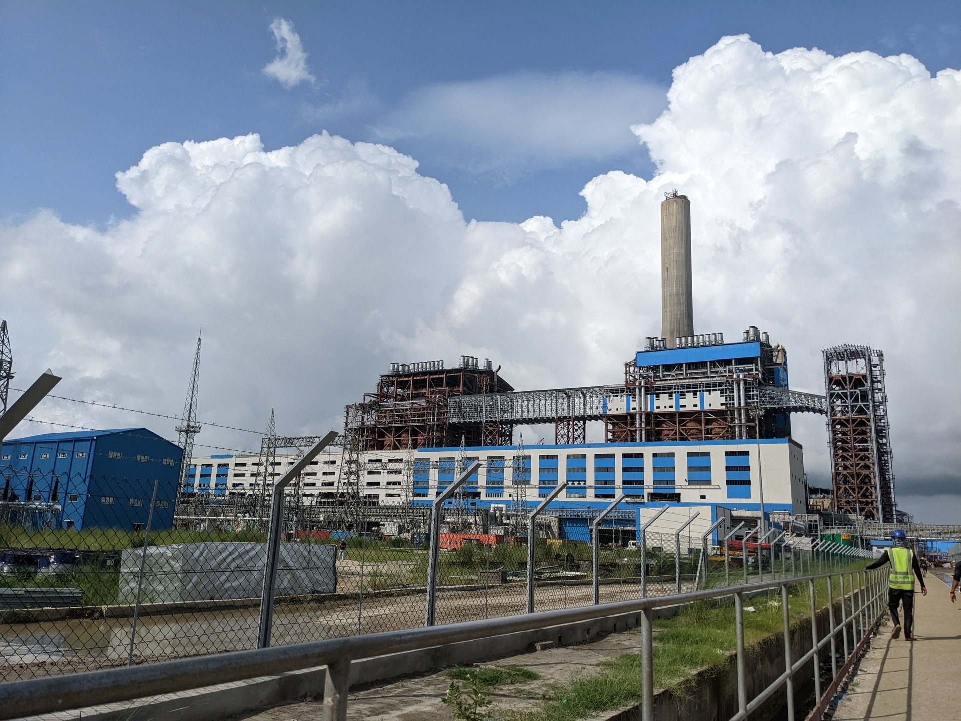 Industrial power plant perimeter with workers and security fencing